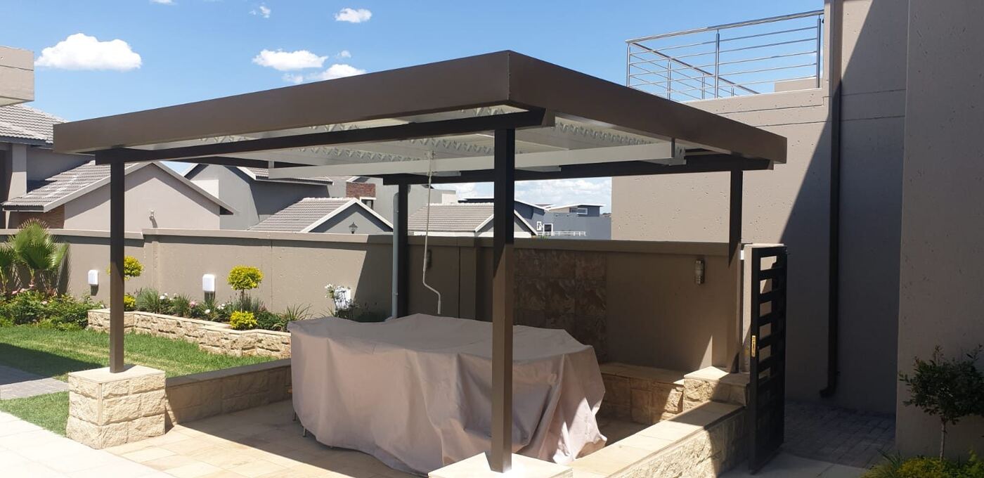 Bronze frame, white blades aluminium louvre roof over a patio in Tokai, Cape Town.