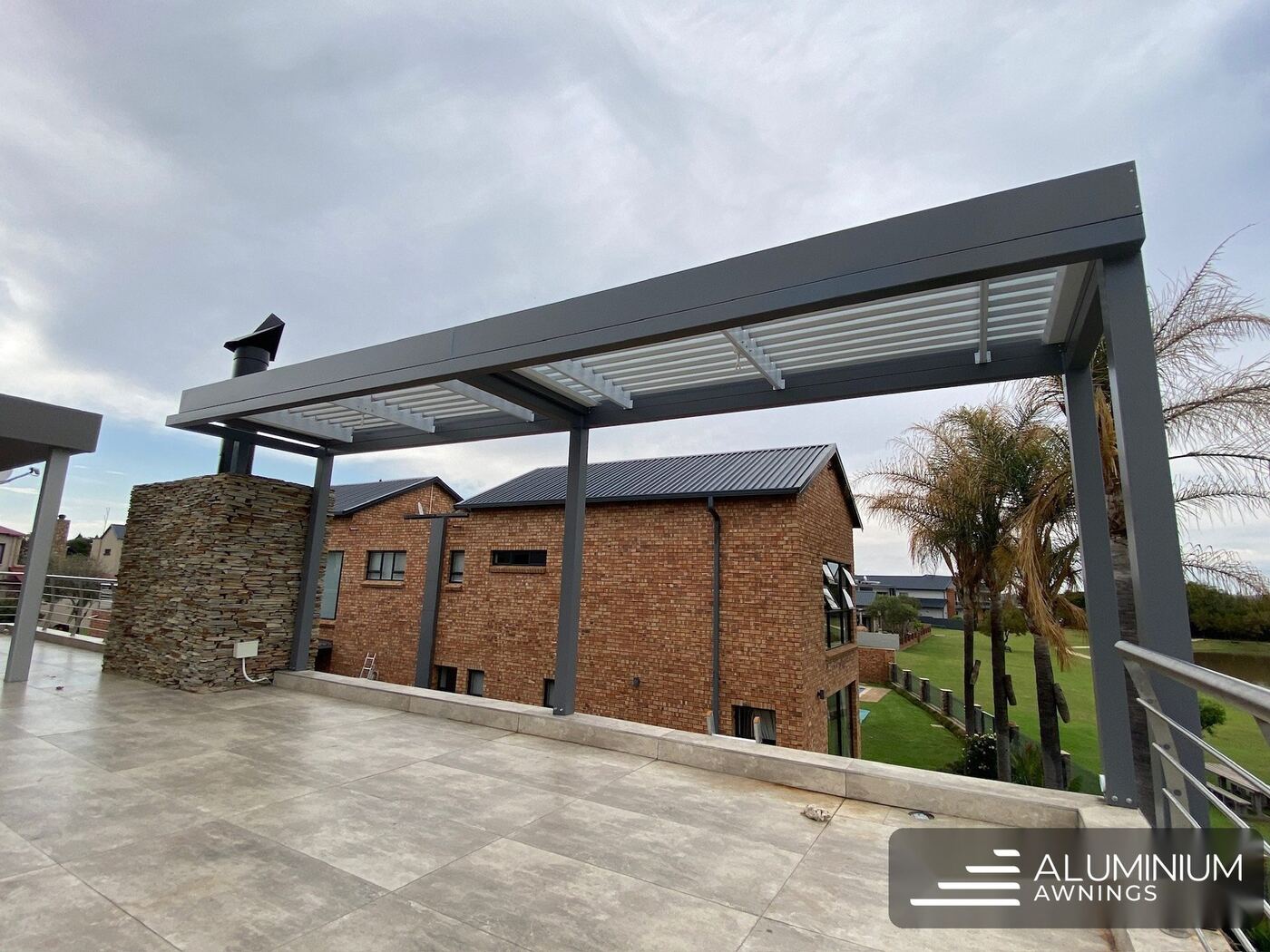 Charcoal-framed aluminium louvre roof over a deck — Constantia, Cape Town