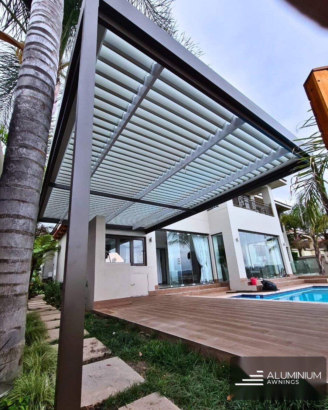 Manual adjustable louvre pergola in bronze frame with white louvre blades — Val de Vie Estate, Paarl