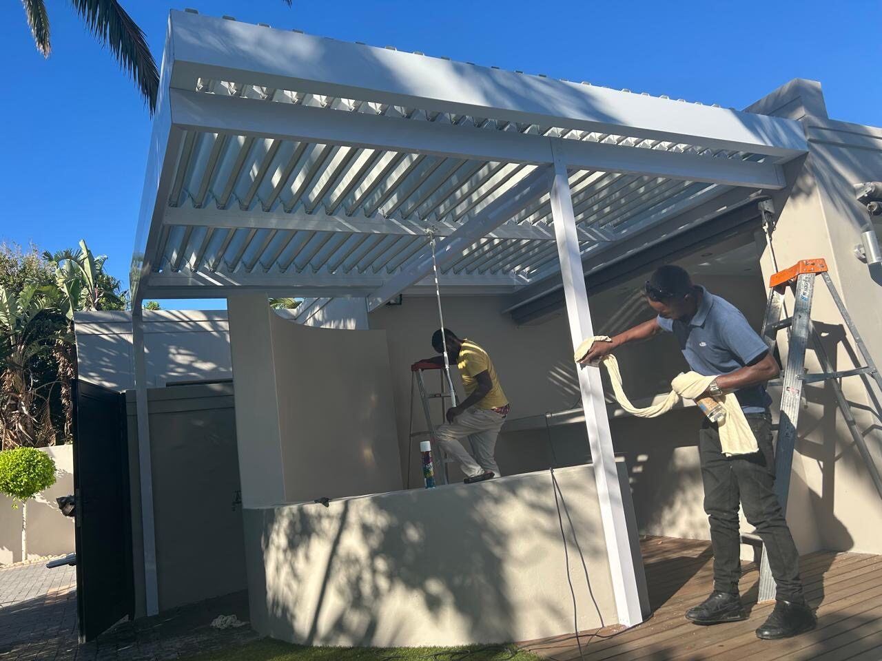 White frame & blades aluminium louvre awning over a patio in West Beach, Cape Town.
