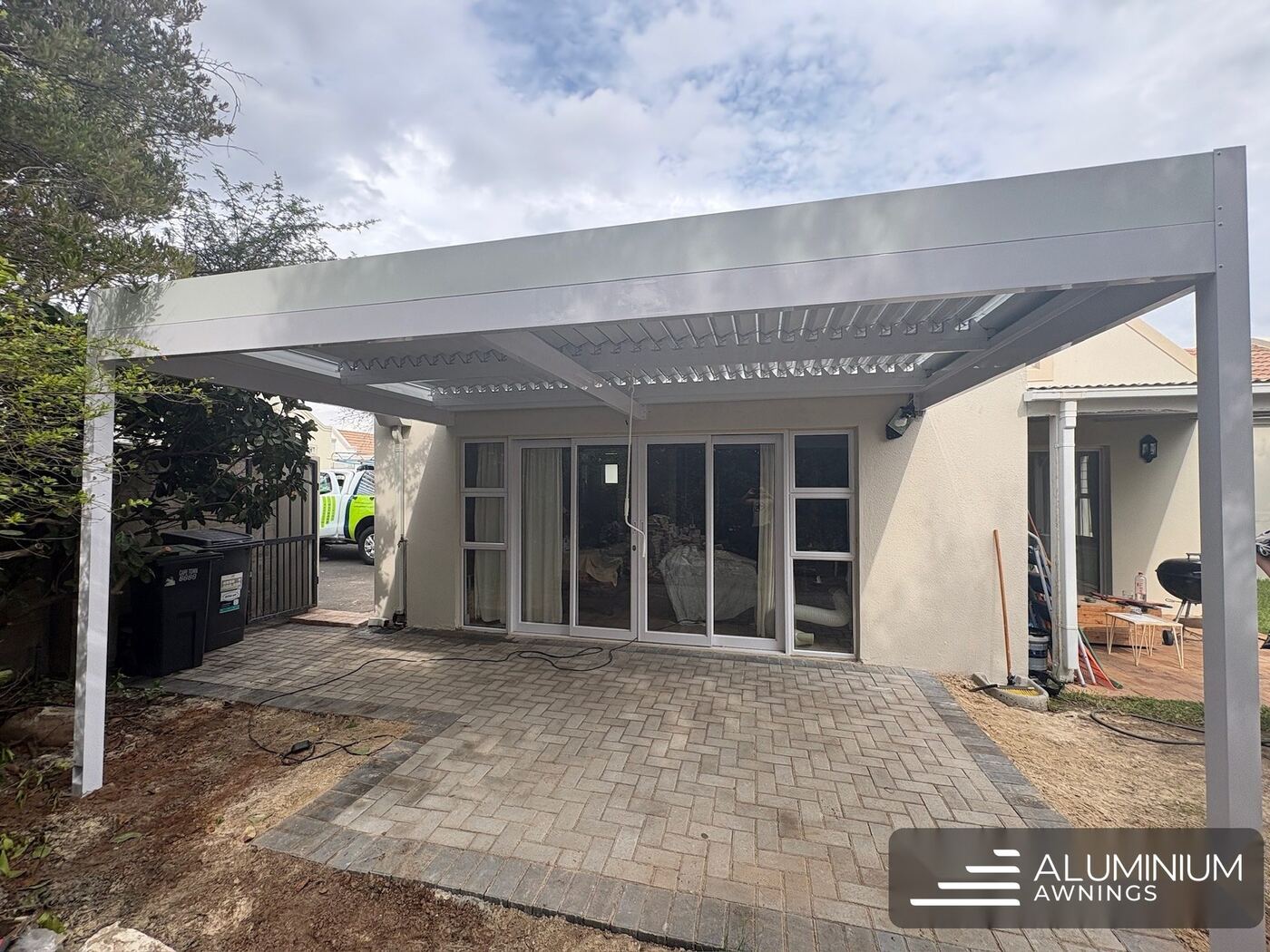 White-framed manual aluminium louvre roof over a Cape Town patio